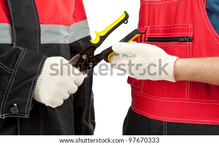 Industrial/construction workers in uniform holding special tool; closeup of men\'s hands holding/giving/taking wire cutter isolated on white