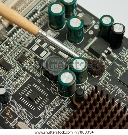 Cleaning computer electronic board; closeup of video card and brush