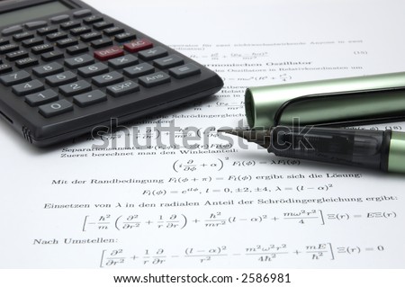 Still life of a calculator and an open pen on scientific paper