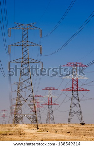 Long lines of power-line towers stretching across the Qatar desert
