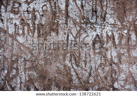 A wall with etched on graffiti. Good background image.