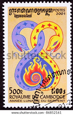 CAMBODIA - CIRCA 2001:  A postage stamp printed in Cambodia commemorates the Chinese Year of the Snake 2001, showing a yellow and purple snakes creating a heart shape with flames inside, circa 2001.