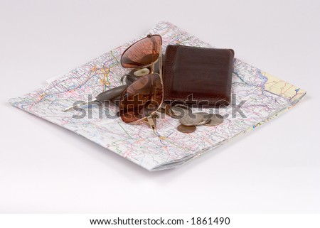 Isolated Pile of Wallet, Coins, Keys, Brown Sun Glasses on Road map