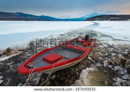 Red boat with Mount Fuji at Yamanaka Lake, after the heavy snow storms in the past 120 years in 20 February 2014