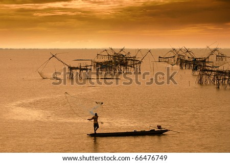 silhouette of fishermen throwing fishing net