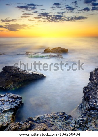 Sun glow and clouds at sunset. Bright seascape