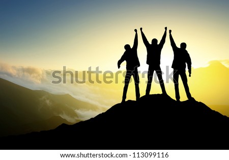 Silhouette of the team on the peak of mountain. Sport and active life