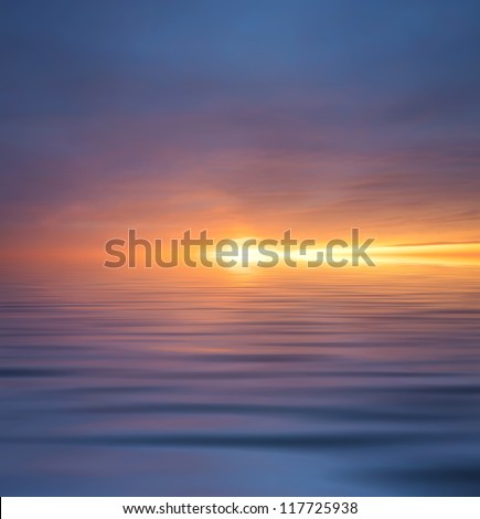 Sun glow and reflection in water surface during sunset.
