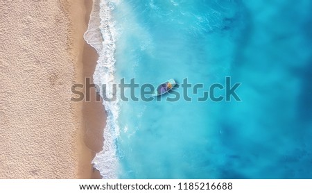 Boat on the water surface from top view. Turquoise water background from top view. Summer seascape from air. Travel concept and idea