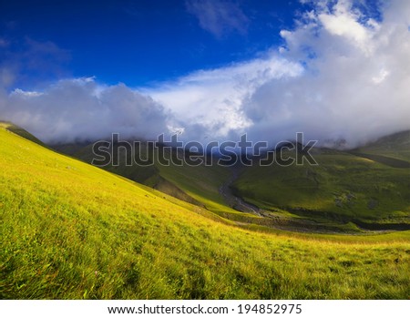 Grass and clouds in mountain valley. Beautiful natural landscape