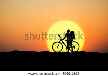 Silhouette of a biker on the mountain top. Sport and active life concept