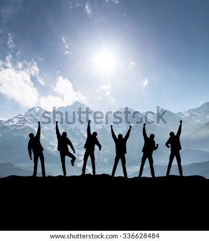Silhouettes of team on mountain peak. Sport and active life concept