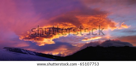 Enormous cloud during dawning on mountain. Natural composition