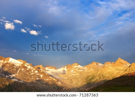 Bright mountains during sundown on background blue sky