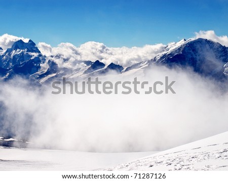 Big white cloud and dark mountains. Natural composition