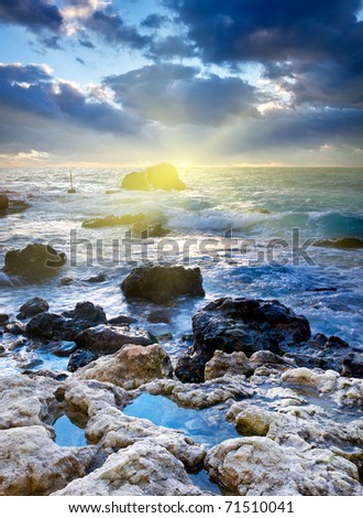 Stone and storm sea during sundown. Natural composition