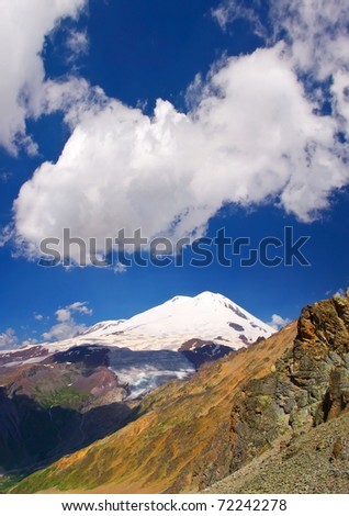 High mountain with snow on background bright sky. Natural composition