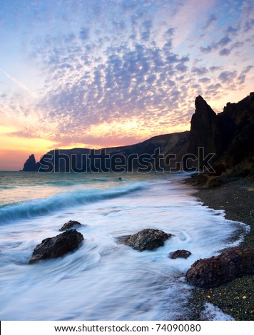 Seashore with greater wave on background bright sky during sundown. Composition of the nature