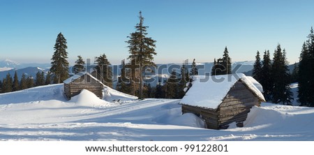 Houses in mountain valley. Winter composition