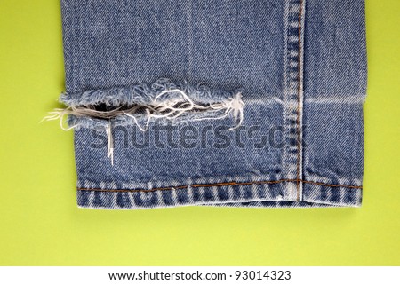 Frayed denim jeans with green background