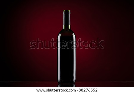 Bottle of red wine on red gradient background
