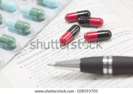 Concept of medical treatment contain many pills and textbook