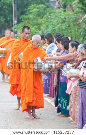 SANGKHLABURI , THAILAND - OCT. 3: An unidentified woman Gives food  to a monk.Thai traditional, people will make merit making by give food to monk on October 3, 2011 in Sangklaburi, Thailand.