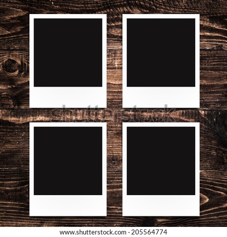 blank photo frames on wood background
