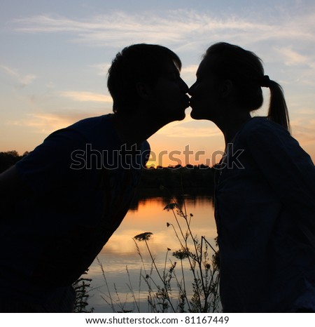 Summer romance / Kissing couple silhouette at sunset