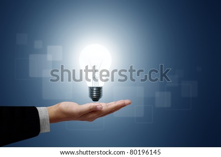 Light bulb in hand businessman on blue background.
