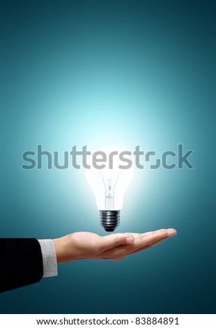 White light bulb on the hand businessmen on green background