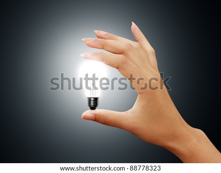 light bulb small on woman hand on gray background