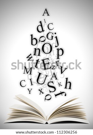 Open book with falling letters over grey background