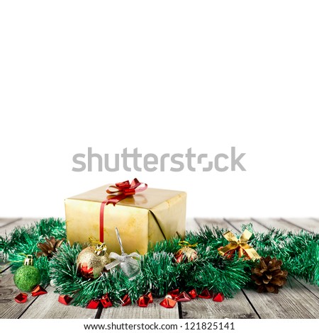 Golden christmas gift box with christmas balls on wood planks over white background