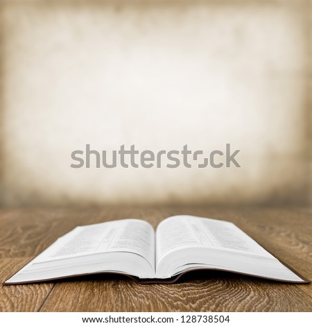 Open Book On Wood Table Over Grunge Background