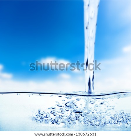 Flowing water and air bubbles over sky background