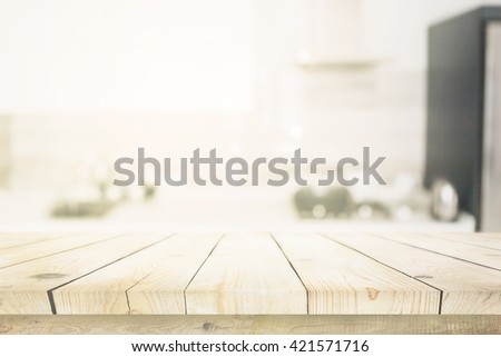 Wooden table over blured kitchen interior background
