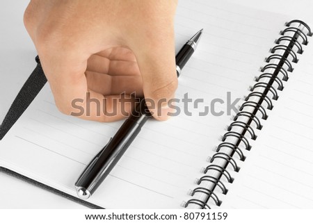 Hand taking the pen on the notebook