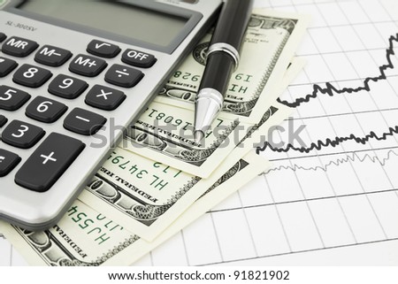 Pen,calculator and dollars on chart closeup. Business concept background