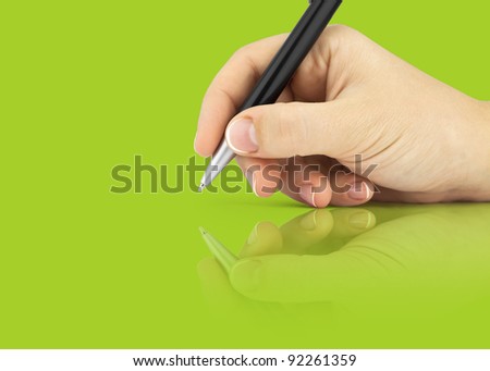 Hand hold a pen writing on the green background