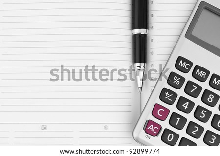Pen, calculator on notebook close up with space for text