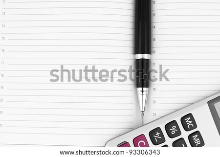 Pen, calculator on notebook close up with space for text
