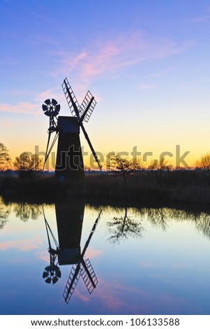 Turf Fen wind pump reflecting in the river Ant at sunset
