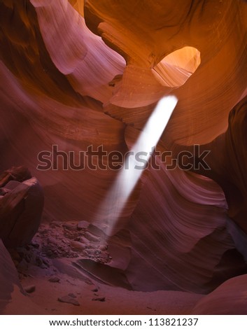 A beam of light streams from The Eye in Antelope Canyon