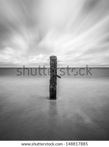 A solitary post surrounded by the rising tide
