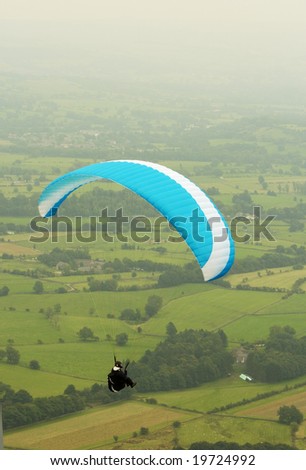 A man paragliding over the hope valley in Derbyshire. Peak District. September 2008