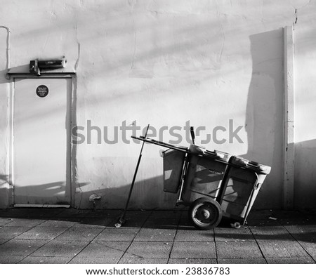 An unatended street sweeper\'s cart in a back street