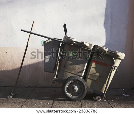 An unatended street sweeper\'s cart in a back street