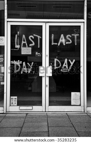 A closed down shop with the words Last Day wrtten on the glass doors