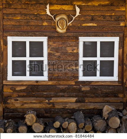 A cowboy hat hangs on the wall of a log cabin in Utah